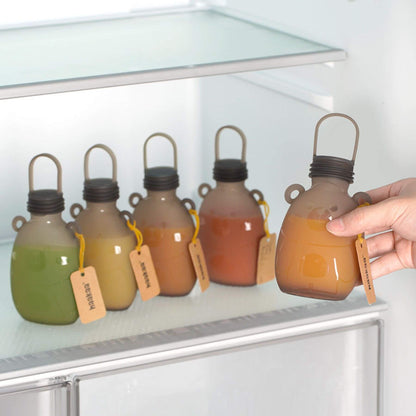 Set of Haakaa Happii Bear Silicone Goody Pouches on a refrigerator shelf.