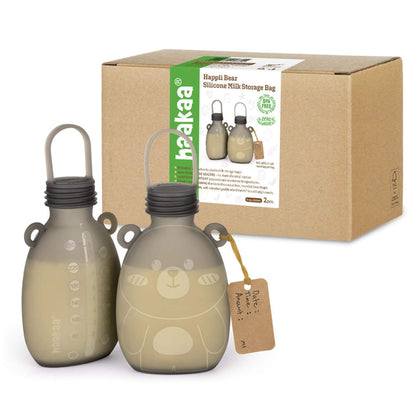 Two beige silicone milk storage bags with a bear design next to their packaging box on a white background.