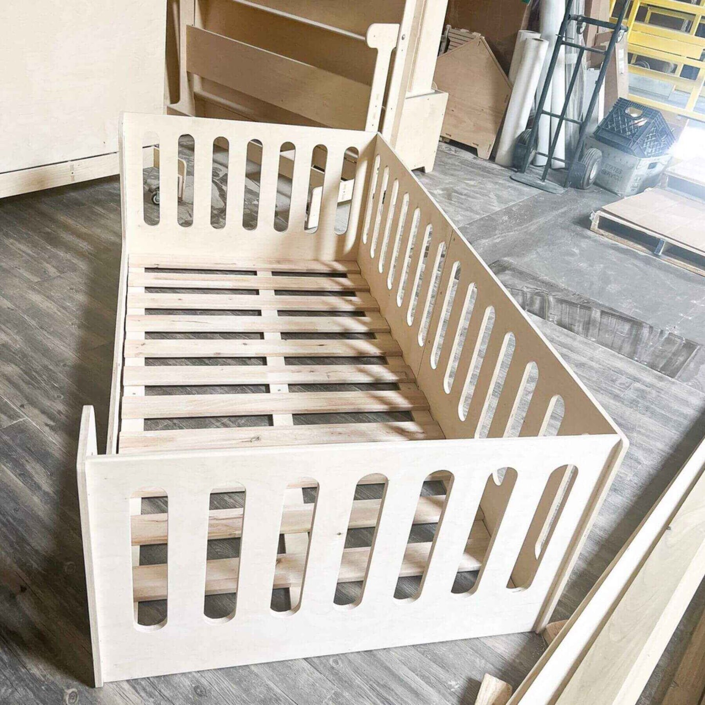 Bush Acres AVI- Floor Bed on a wooden floor with construction materials in the background