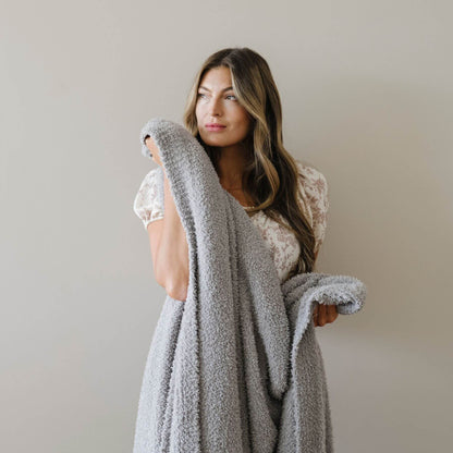 Woman holding BAMBONI® XL Blanket - Gray against a plain background