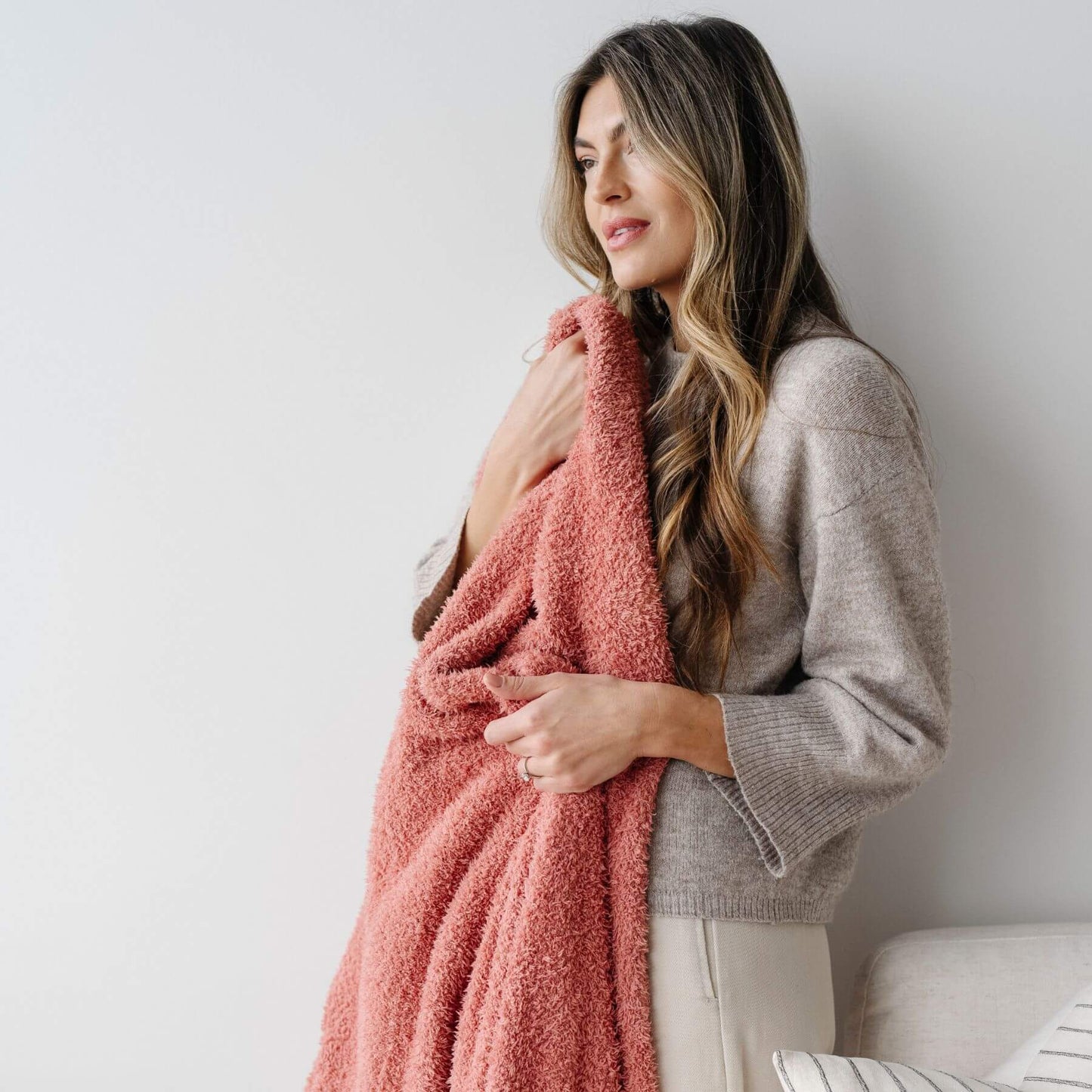 Woman holding BAMBONI® XL Blanket - Hibiscus against a white wall