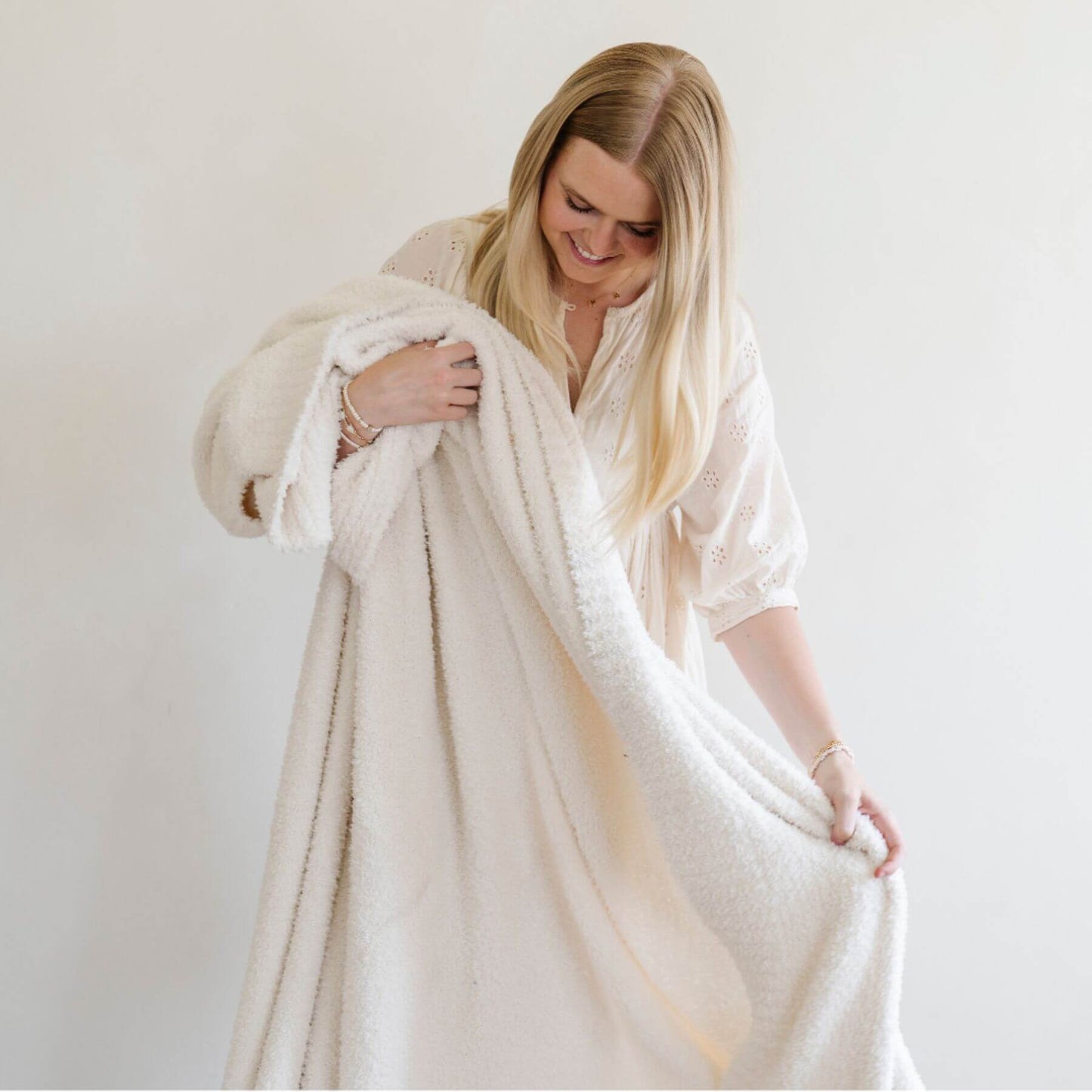 Woman holding BAMBONI® XL Blanket - Ivory against a plain background