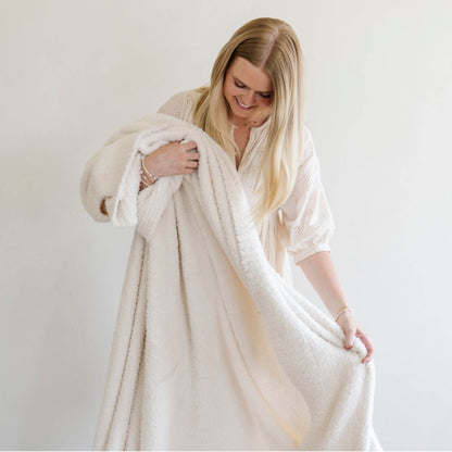 Woman holding BAMBONI® XL Blanket - Ivory against a plain background