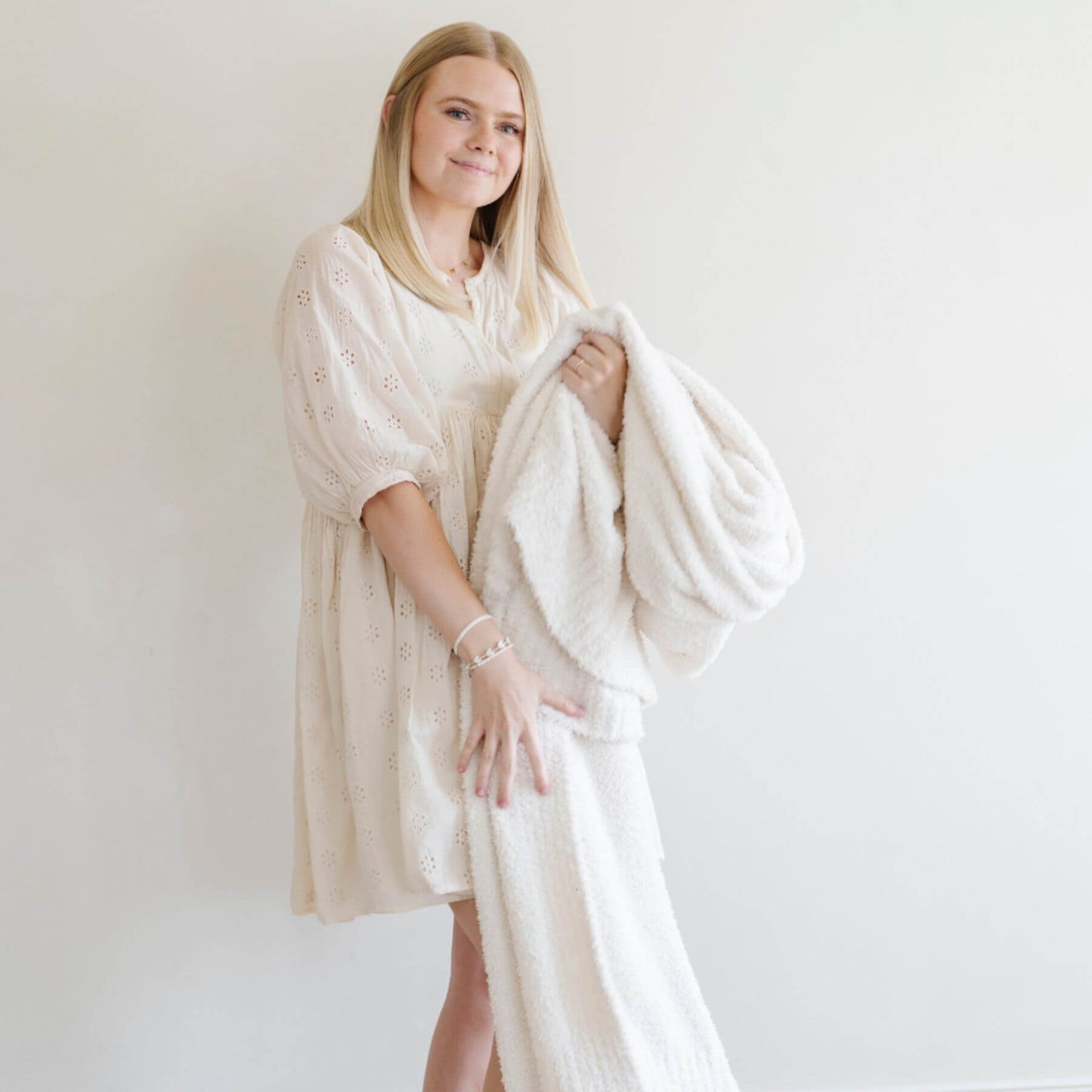 Woman holding BAMBONI® XL Blanket - Ivory against a plain background