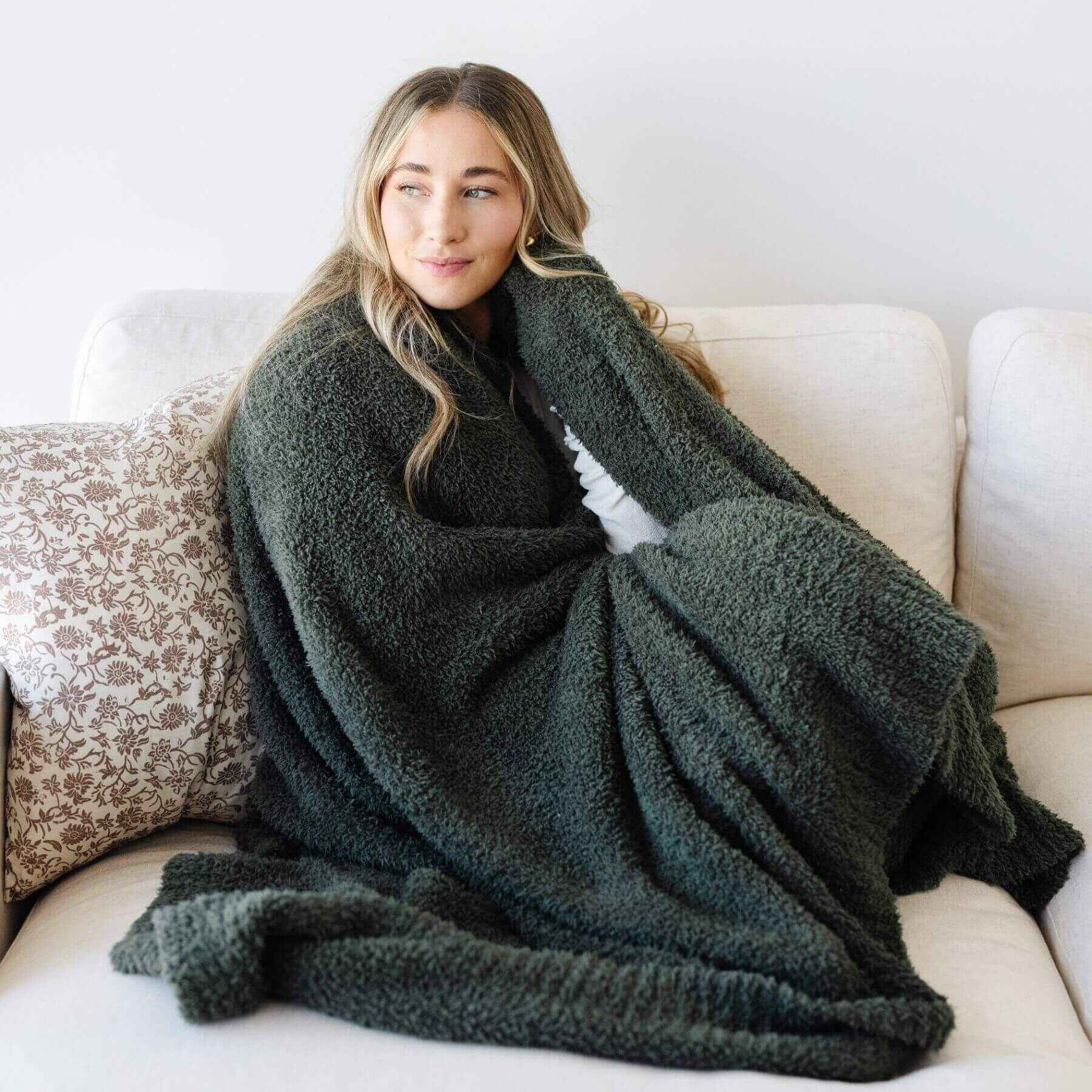 Woman wrapped in BAMBONI® XL Blanket on a couch