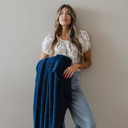 Woman holding BAMBONI® XL Blanket - Nautical against a plain background