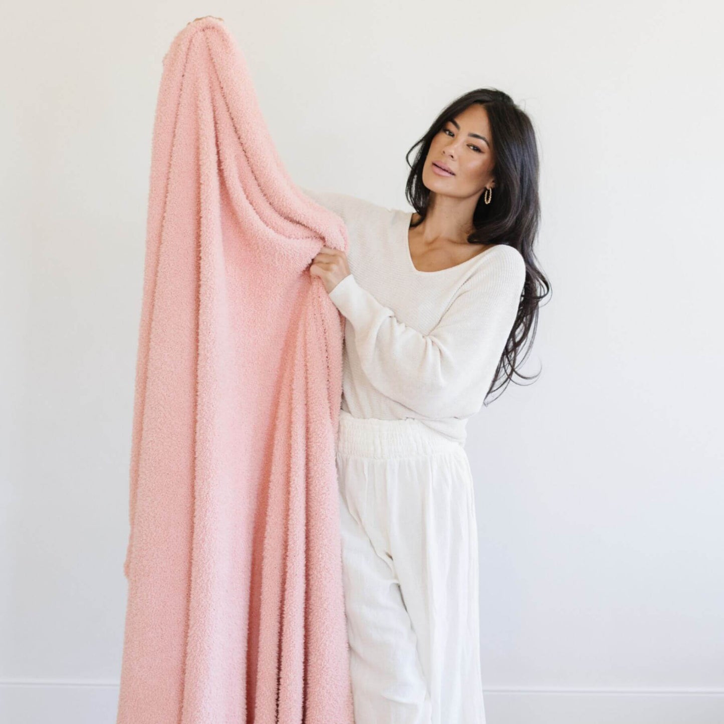 Woman holding BAMBONI® XL Blanket - Peach against a white background