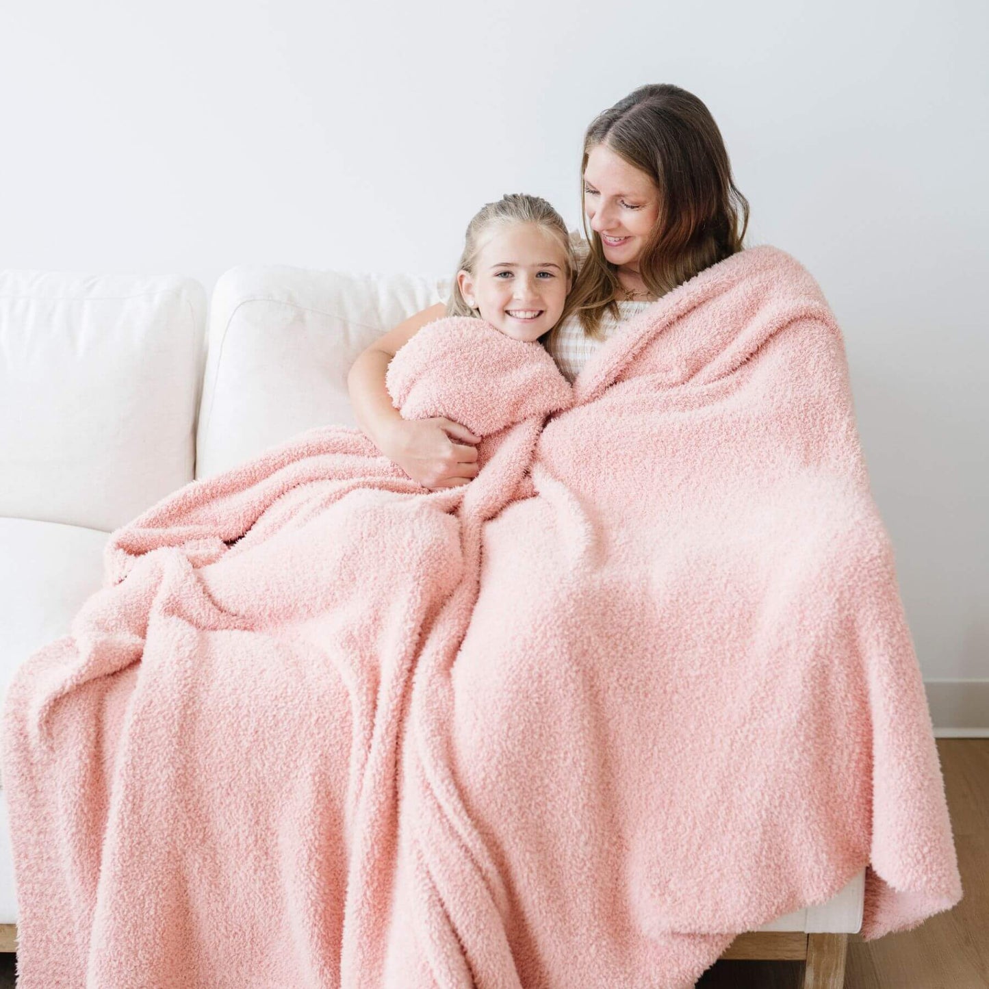 Woman and child wrapped in BAMBONI® XL Blanket - Peach on a couch