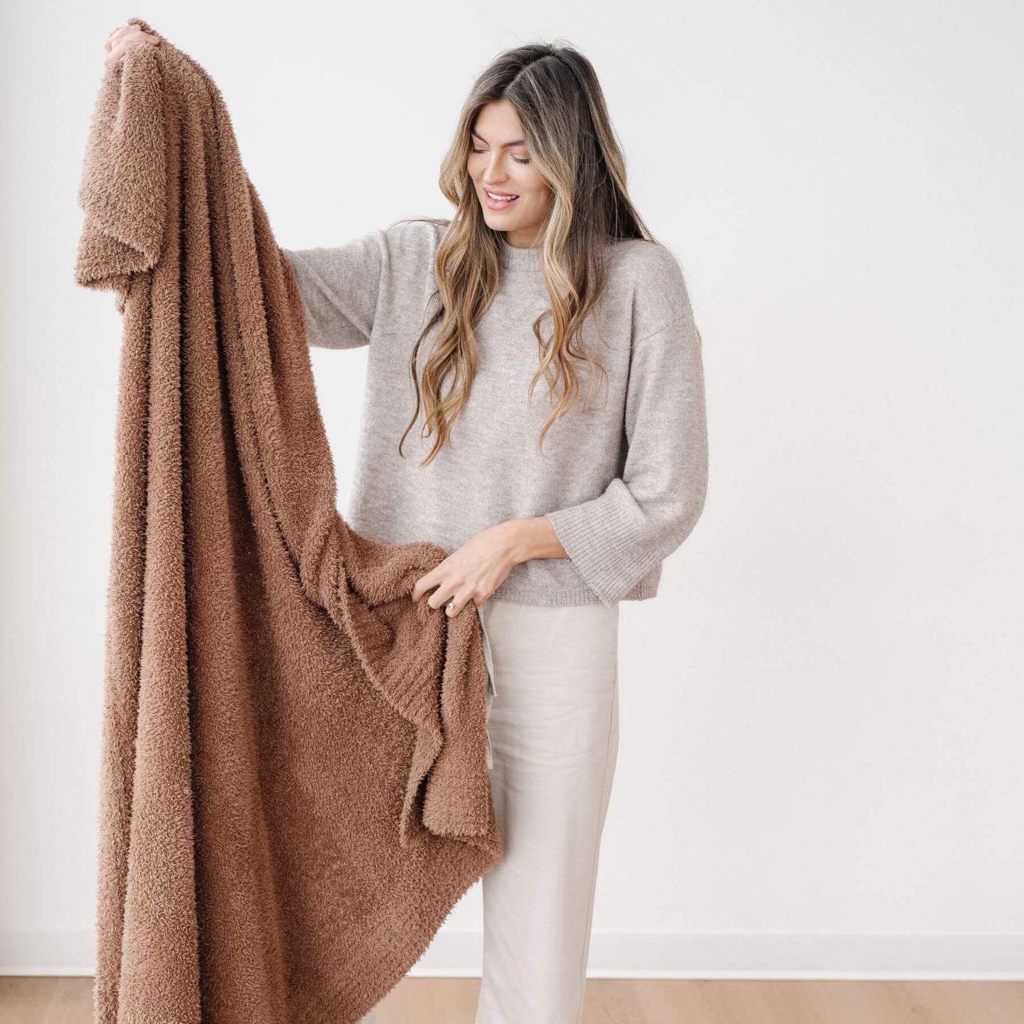 Woman holding BAMBONI® XL Blanket - Pecan against a white background