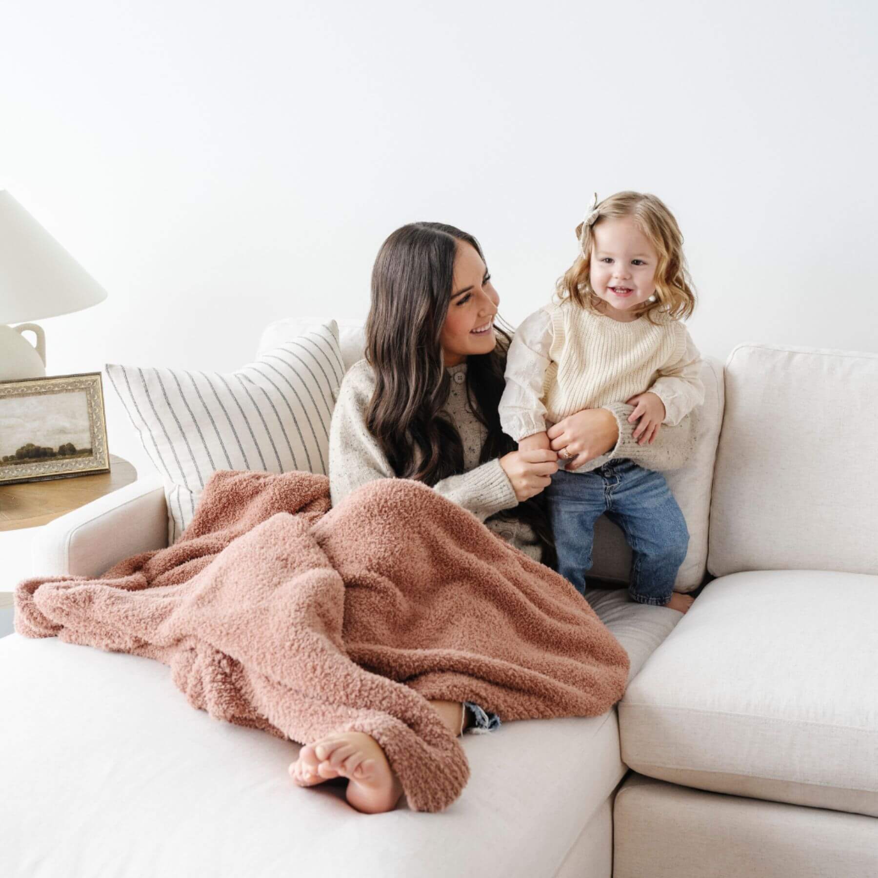 Woman and child sitting on a couch with BAMBONI® XL Blanket - French Rose