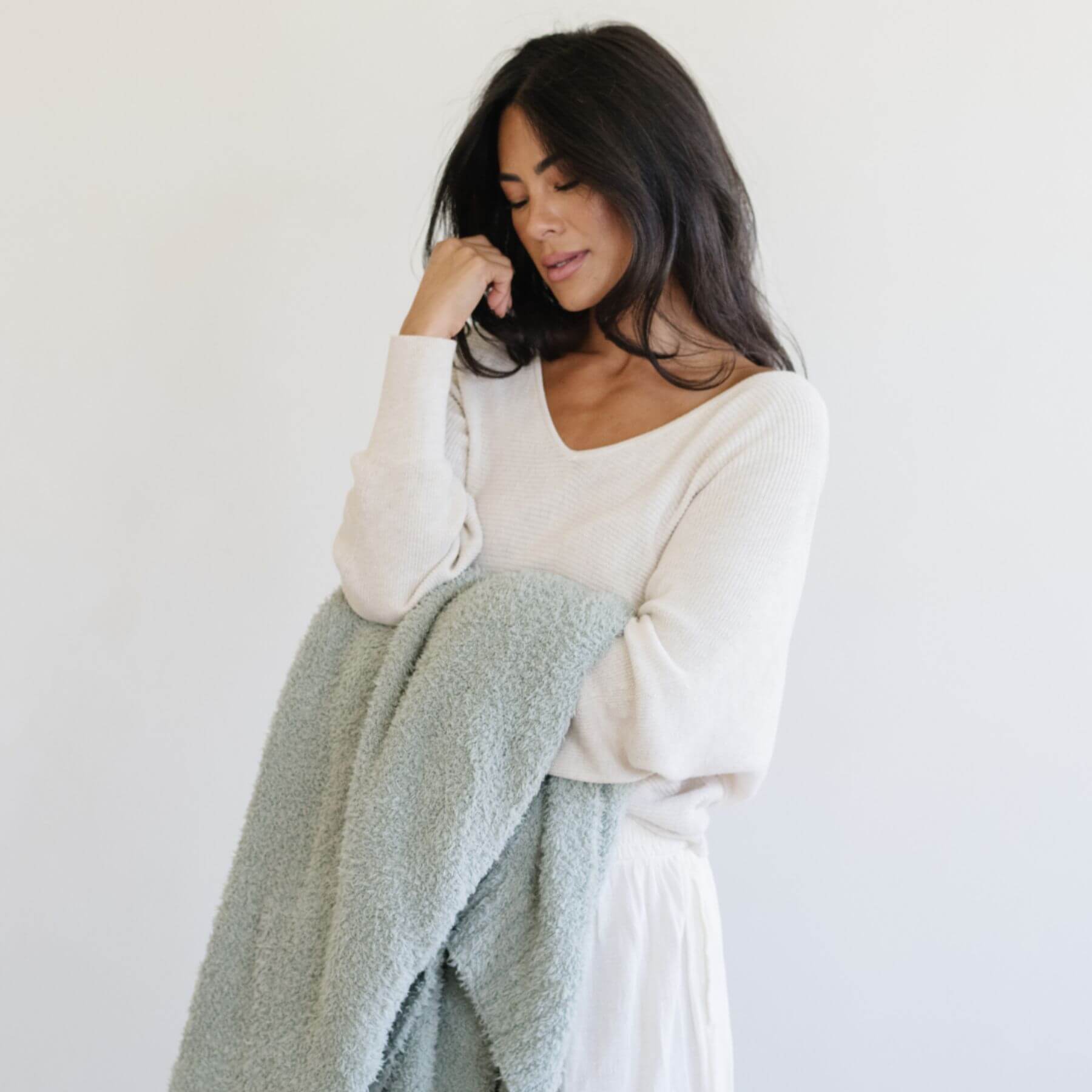 Woman holding BAMBONI® XL Blanket - Sage against a white background