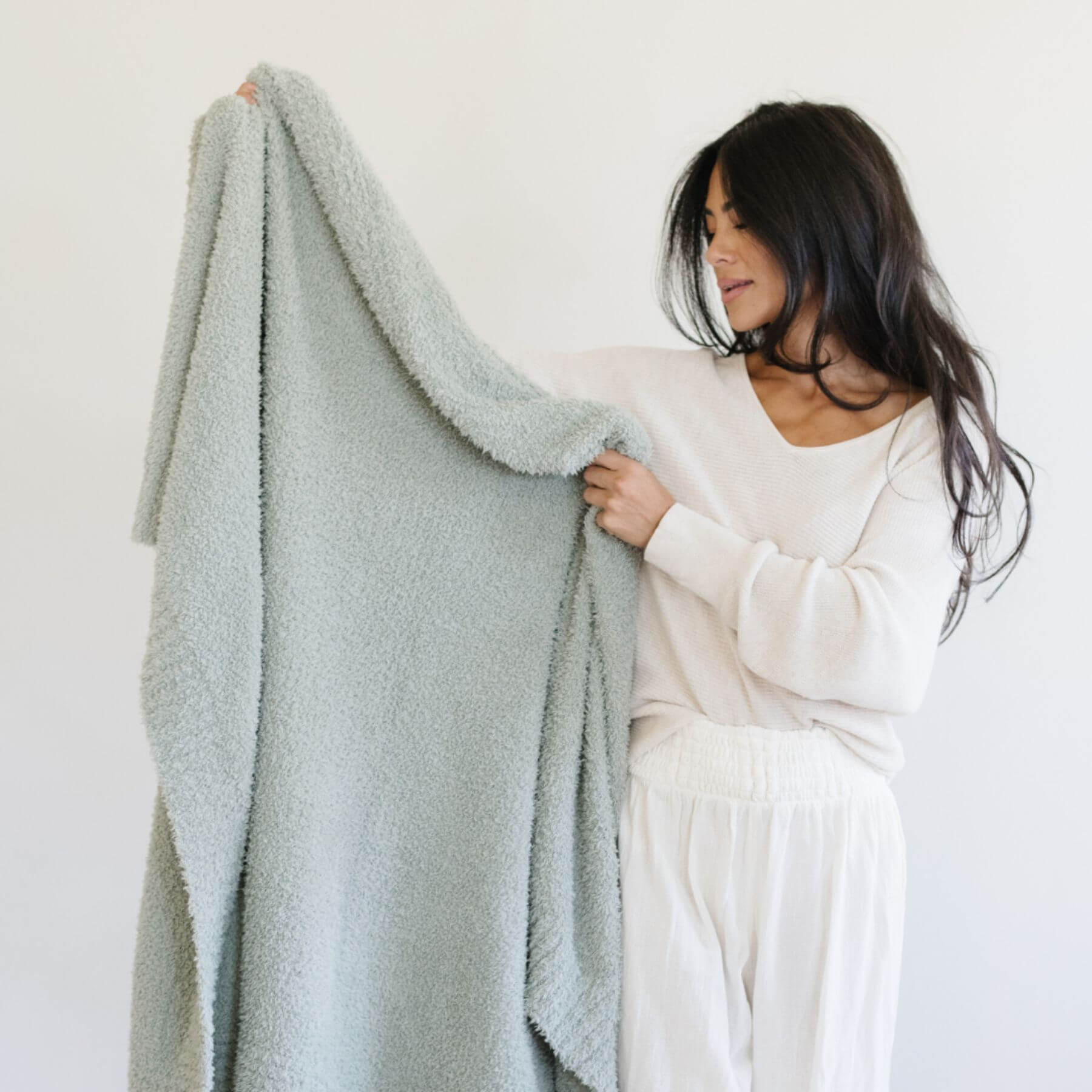 Woman holding BAMBONI® XL Blanket - Sage against a white background