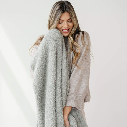 Woman holding BAMBONI® XL Blanket - Sage against a white background