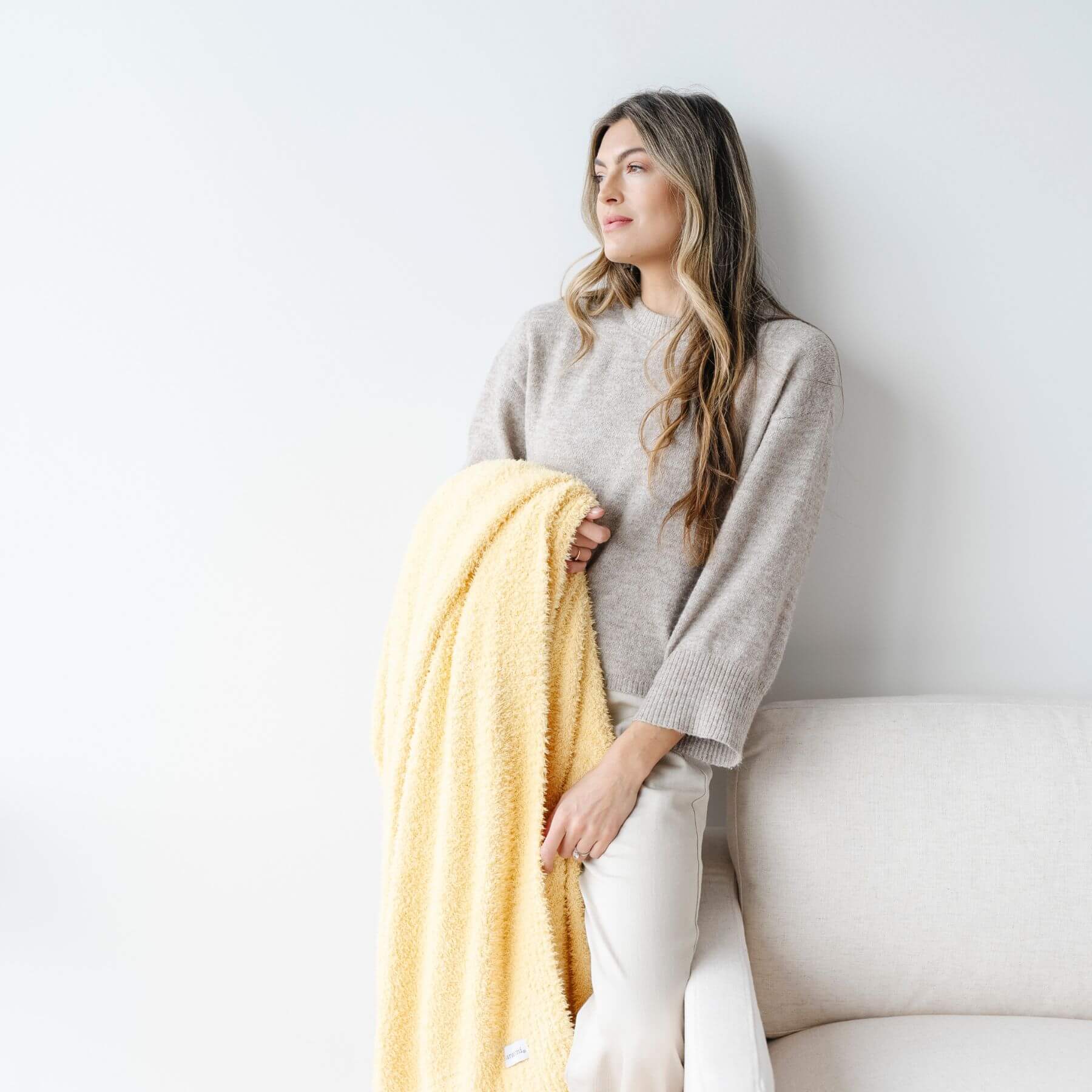 Woman holding BAMBONI® XL Blanket - Sunburst against a white background