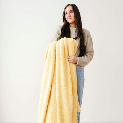 Woman holding BAMBONI® XL Blanket - Sunburst against a plain background
