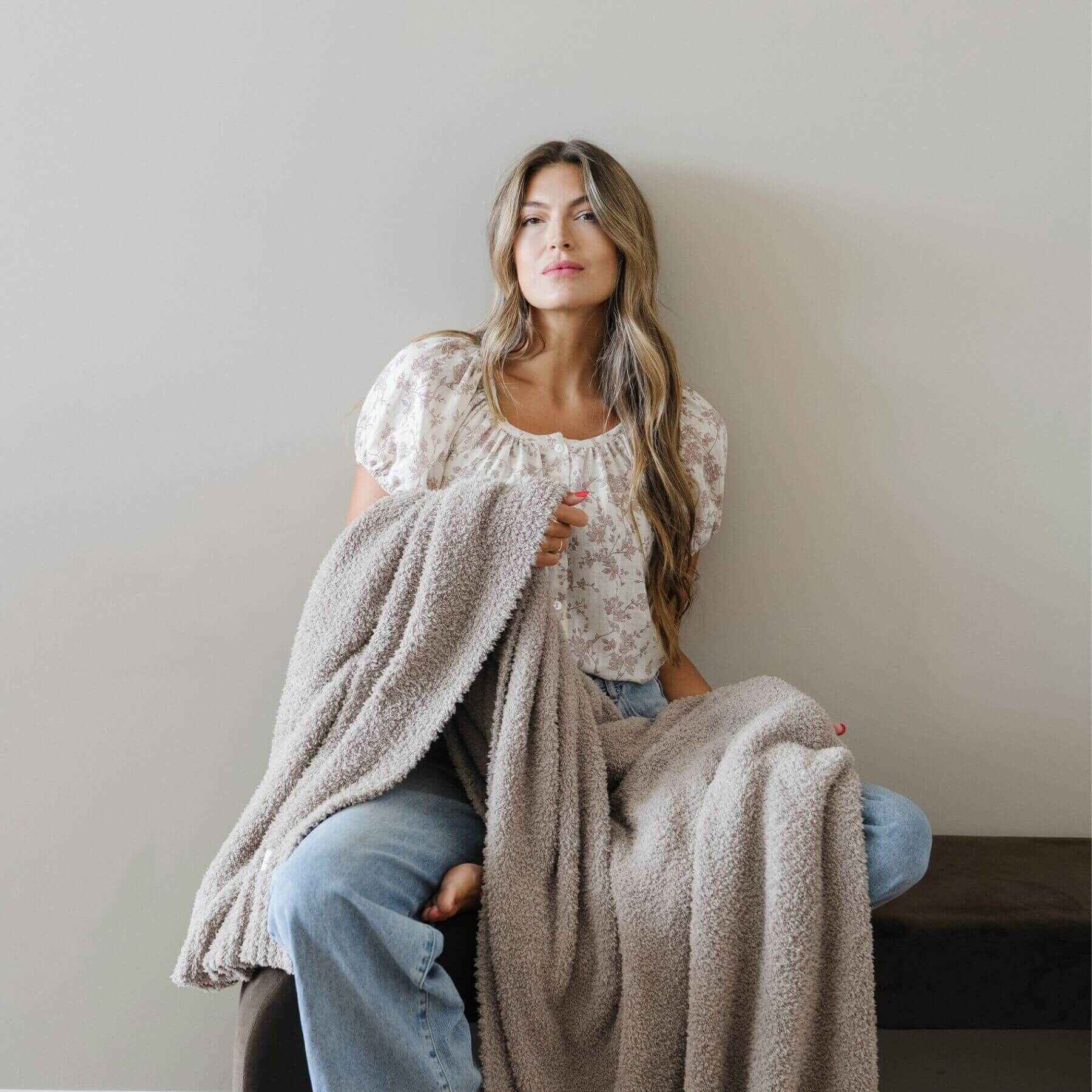 Woman holding BAMBONI® XL Blanket against a plain background