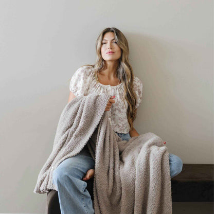 Woman holding BAMBONI® XL Blanket against a plain background