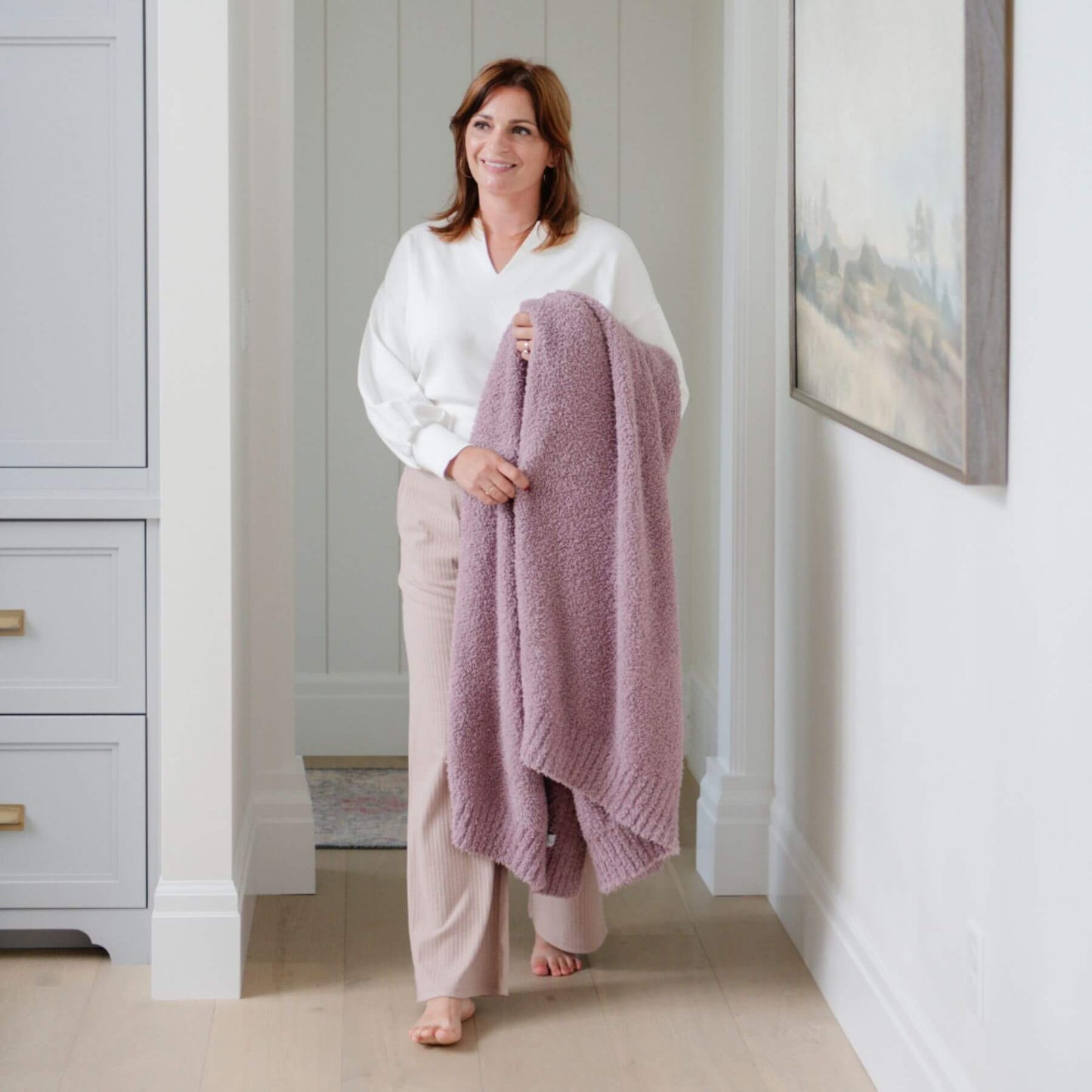 Woman holding BAMBONI® XL Blanket - Woodrose in a home setting