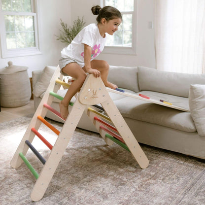 Child playing on a colorful wooden ladder in a living room.