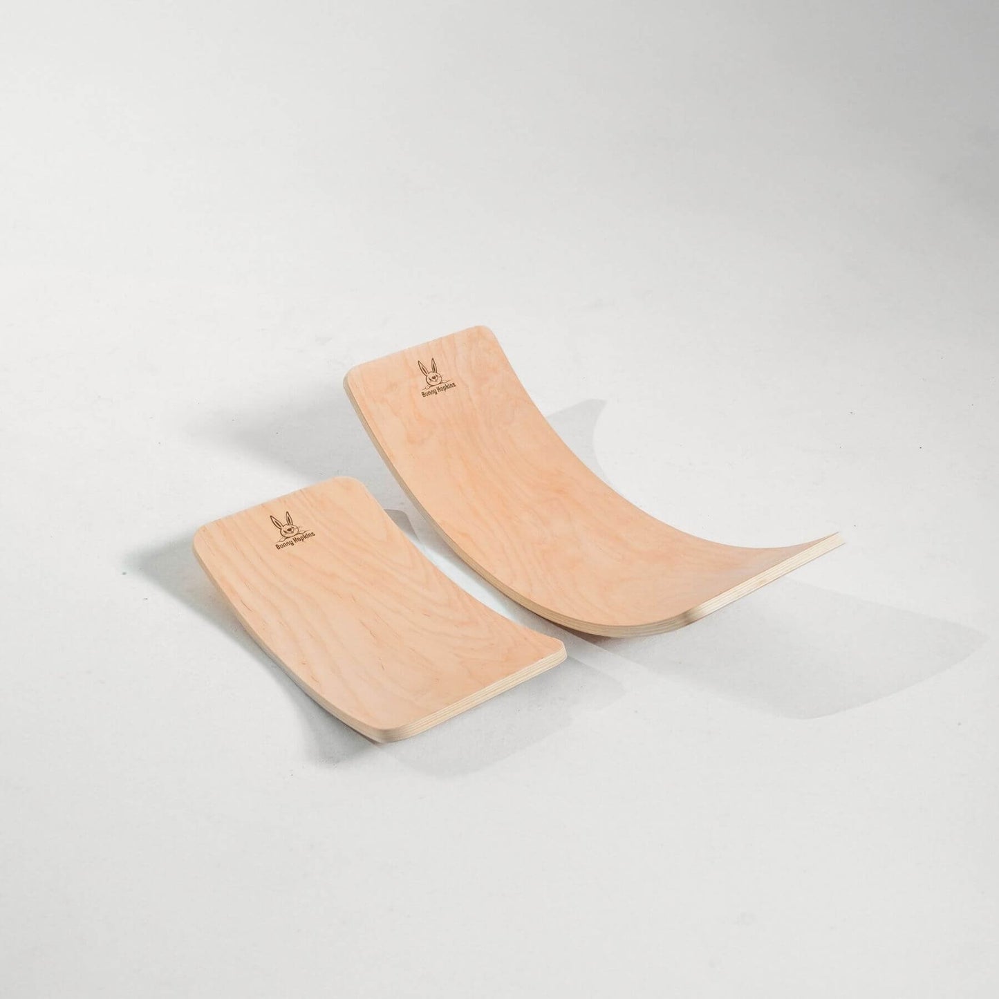 Two wooden balance boards on a light gray background