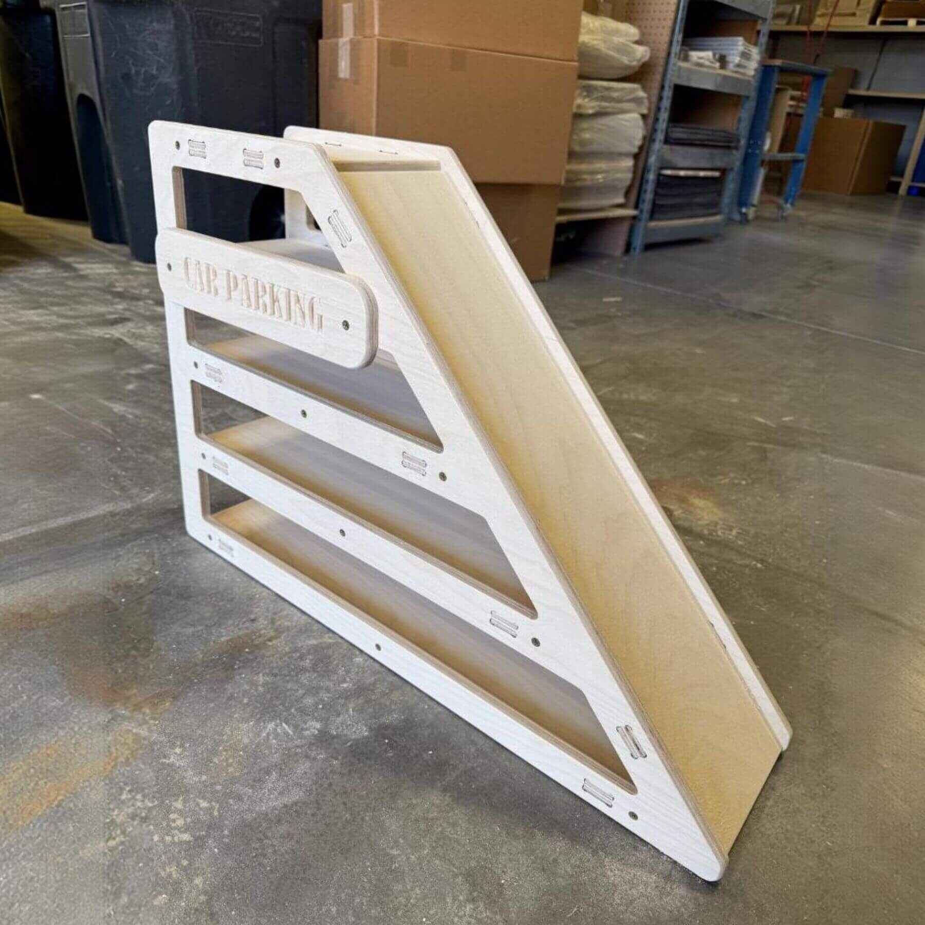 CAMDEN- Toy Car Storage + Ramp on a concrete floor in a warehouse setting.