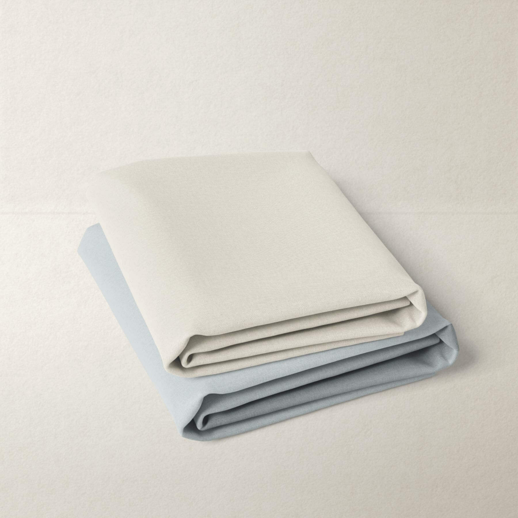 Folded crib sheets in light gray and blue on a light gray background