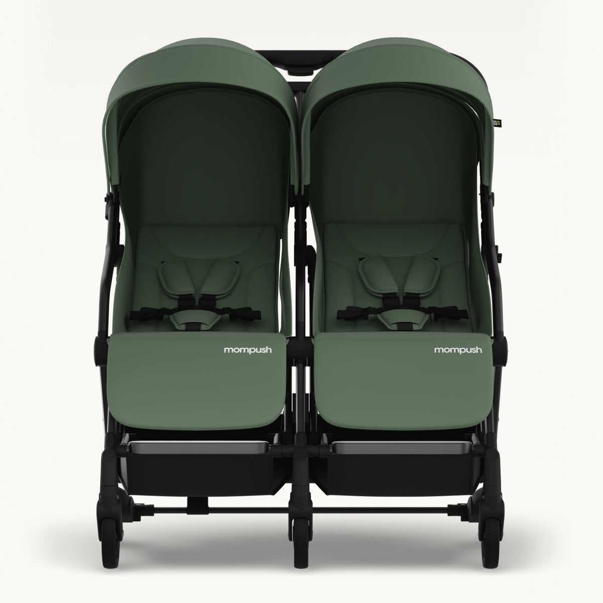 A twin infant stroller in sage green fabric with a black frame, shown from the front against a light gray background. The brand name 'mompush' is visible on the front of each seat.