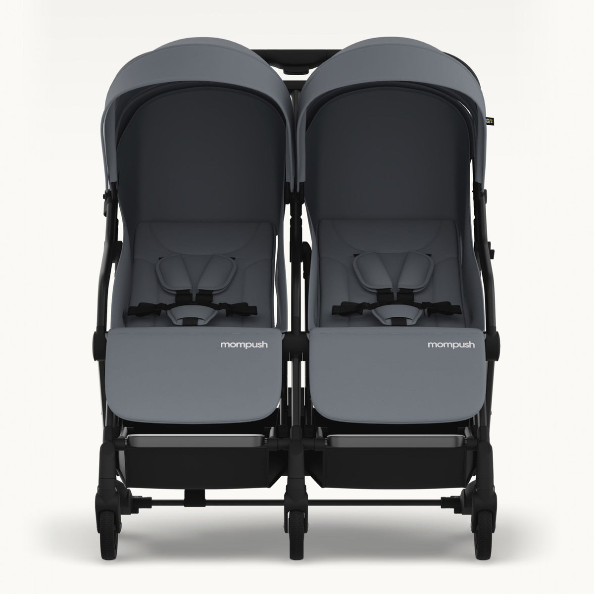 A front-facing view of a double stroller with dark gray fabric seats and canopies, a black frame, and the 'mompush' logo on the front of each seat, set against a plain off-white background.