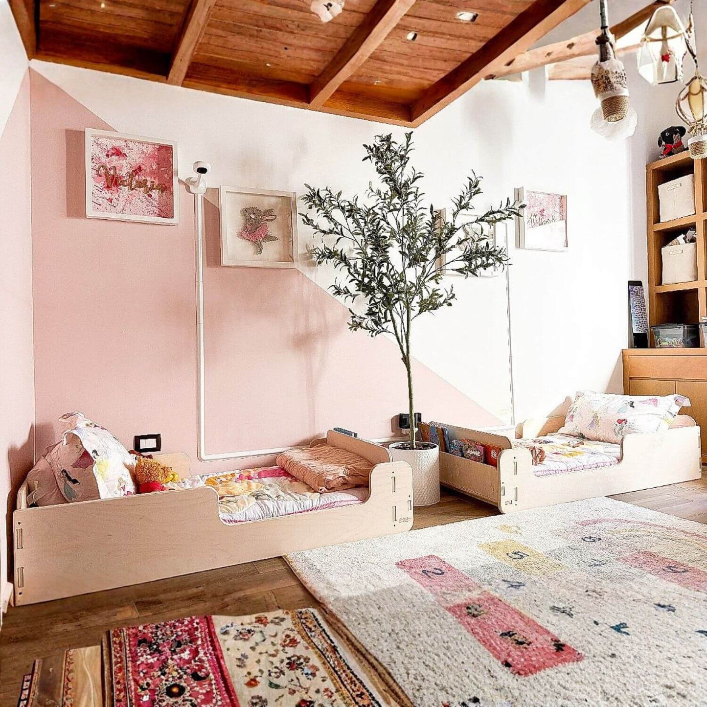 Children's room with two Bush Acres EVA- Floor Beds pink walls, wooden floor, and decorative elements.