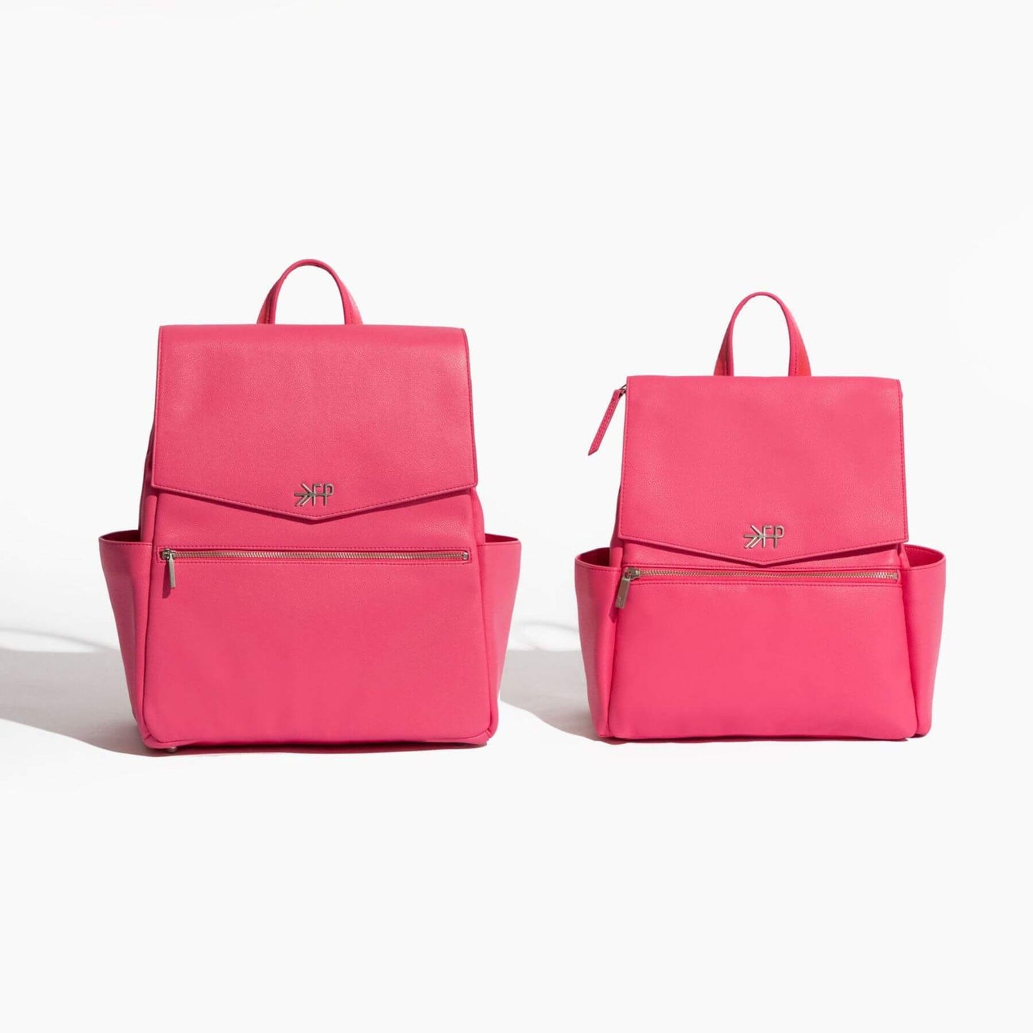 Two pink backpacks on a white background