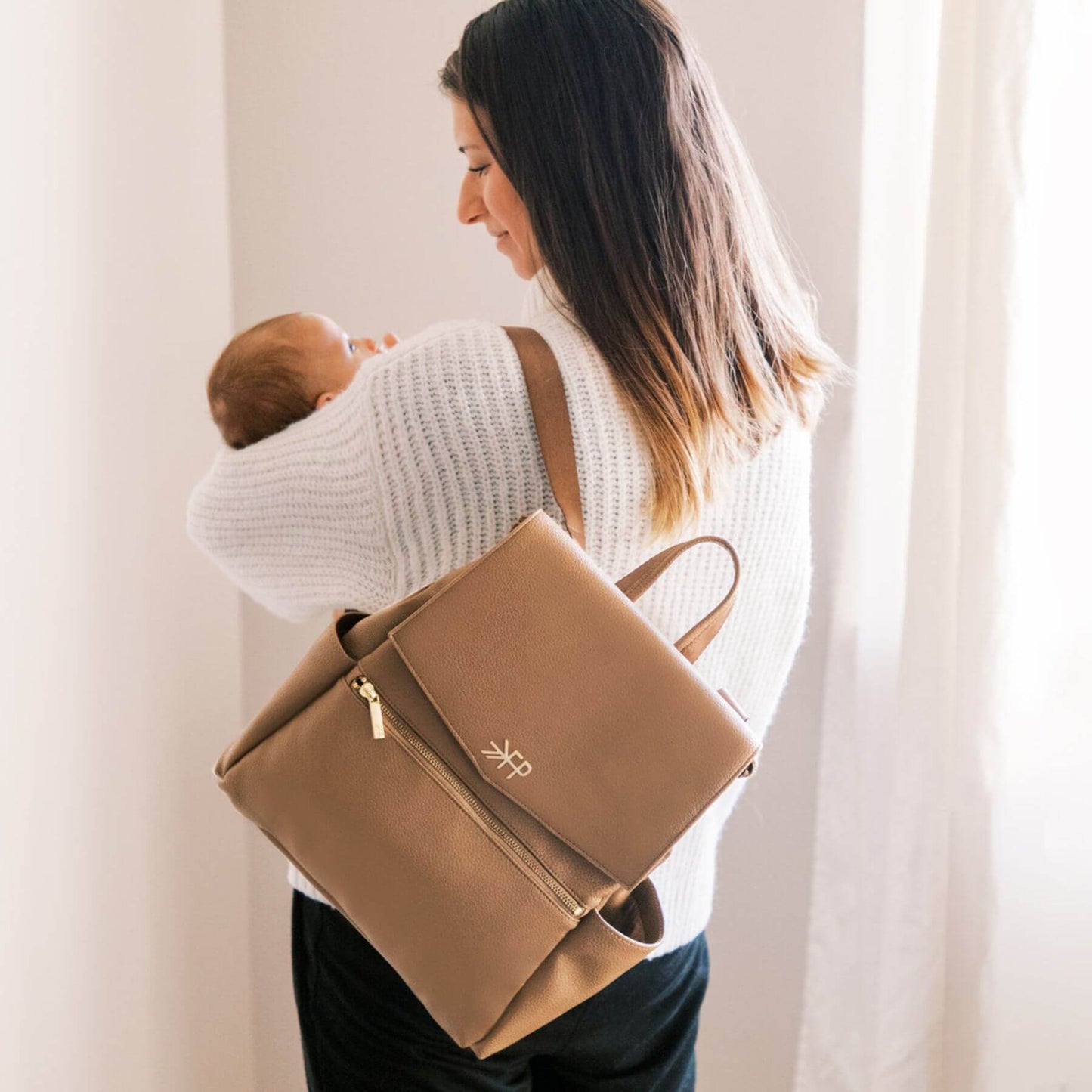 Woman carrying a baby and Freshly Picked Toffee Mini Classic Diaper Bag II