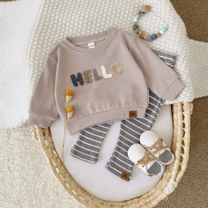 RYAN AND REMI HELLO Striped Pants Set on a textured surface.