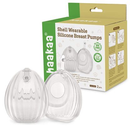 Clear shell-shaped silicone breast pumps with packaging displaying 'haakaa' brand on a white background.