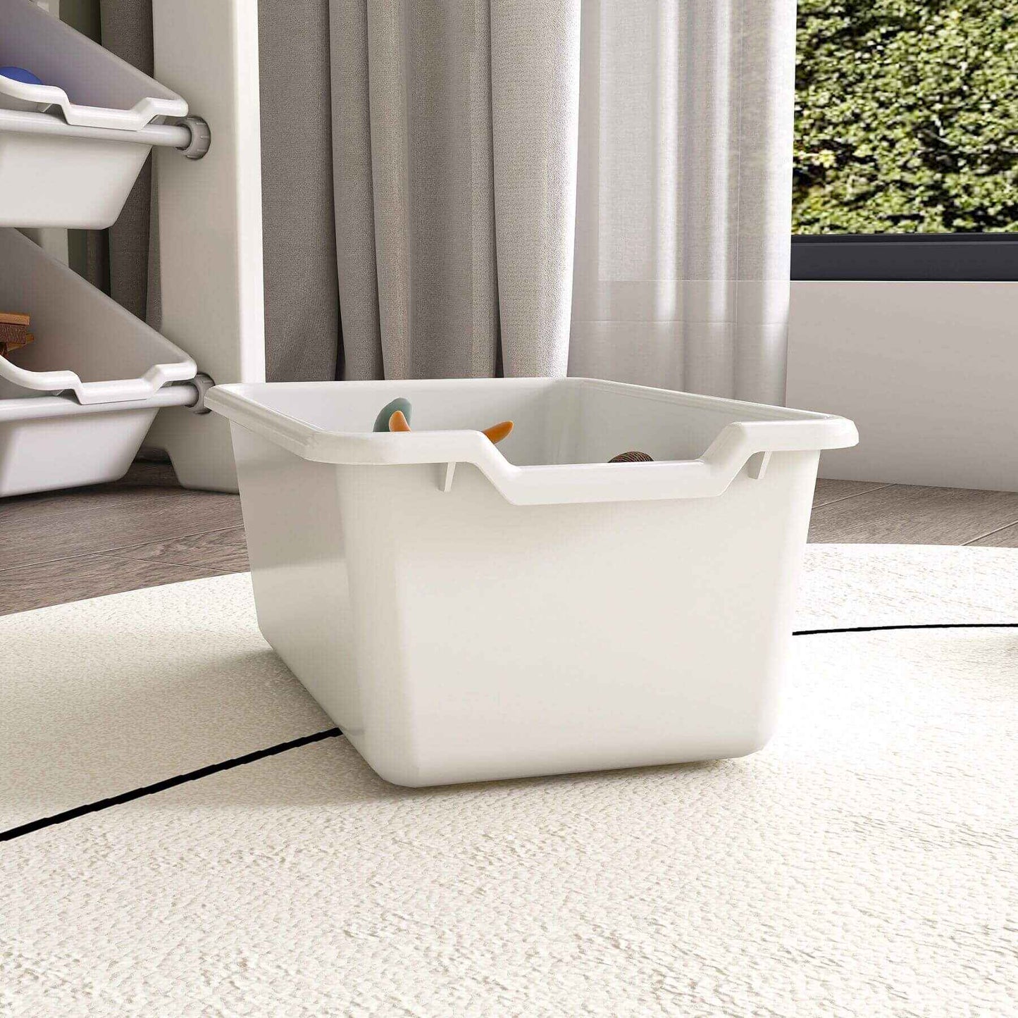 White storage bin with toys on a carpeted floor, with a curtain and window in the background.