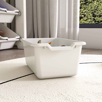 White storage bin with toys on a carpeted floor, with a curtain and window in the background.