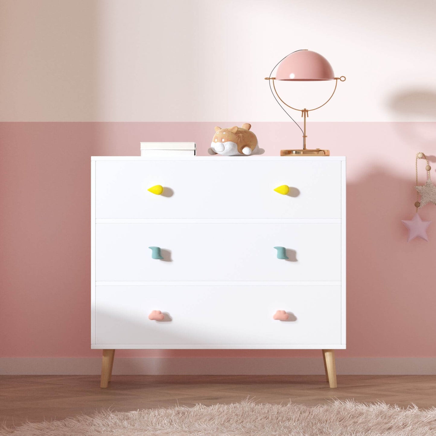 White dresser with colorful knobs against a pink wall