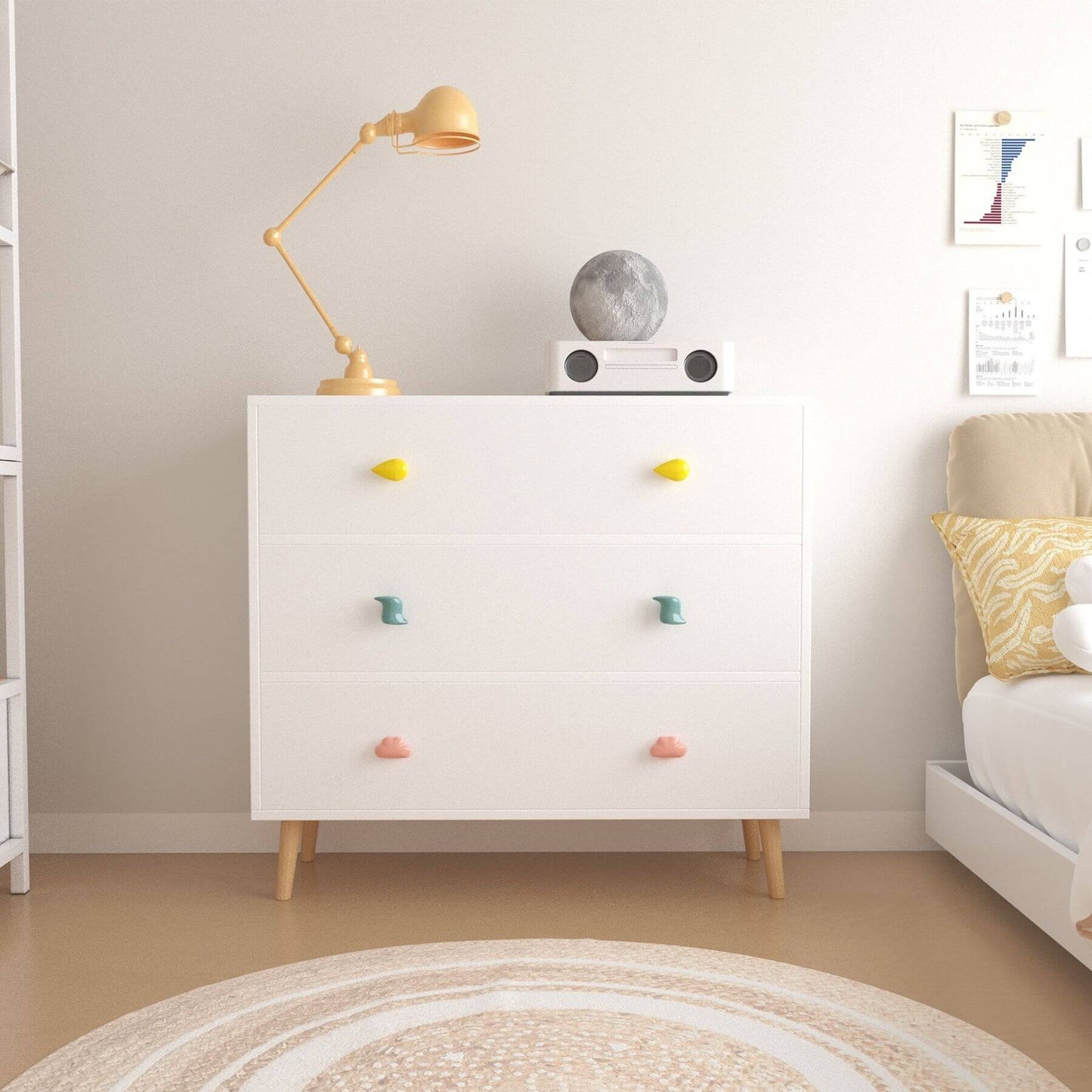 White dresser with colorful knobs in a room with a lamp and decor items.