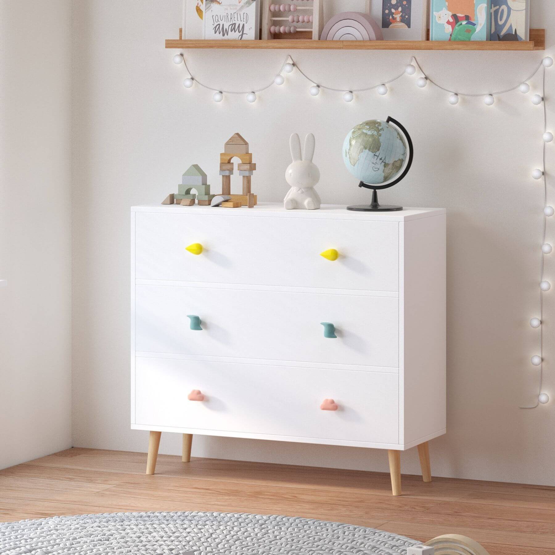 White dresser with colorful knobs in a room with string lights and decor items.