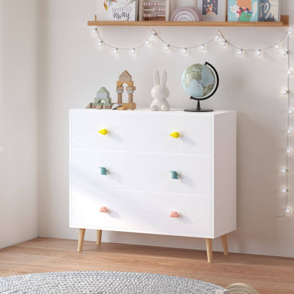 White dresser with colorful knobs in a room with string lights and decor items.