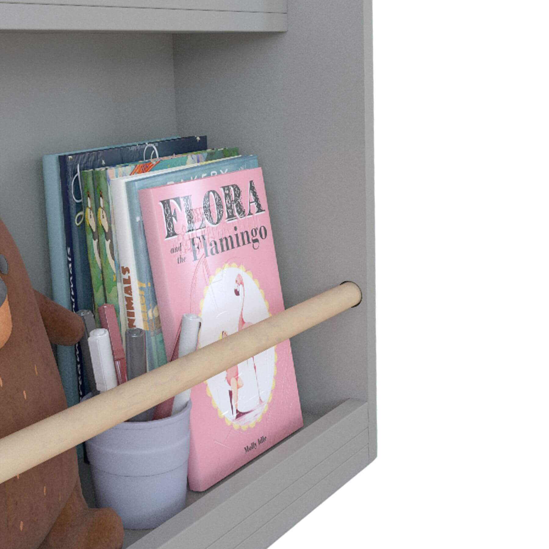 Children's books on a shelf with a pink book titled 'Flora the Flamingo'.