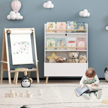 Child reading a book in a playroom with MOONRIVER Kids Bookshelf MDF and Pine Legs - White, easel, and toys.