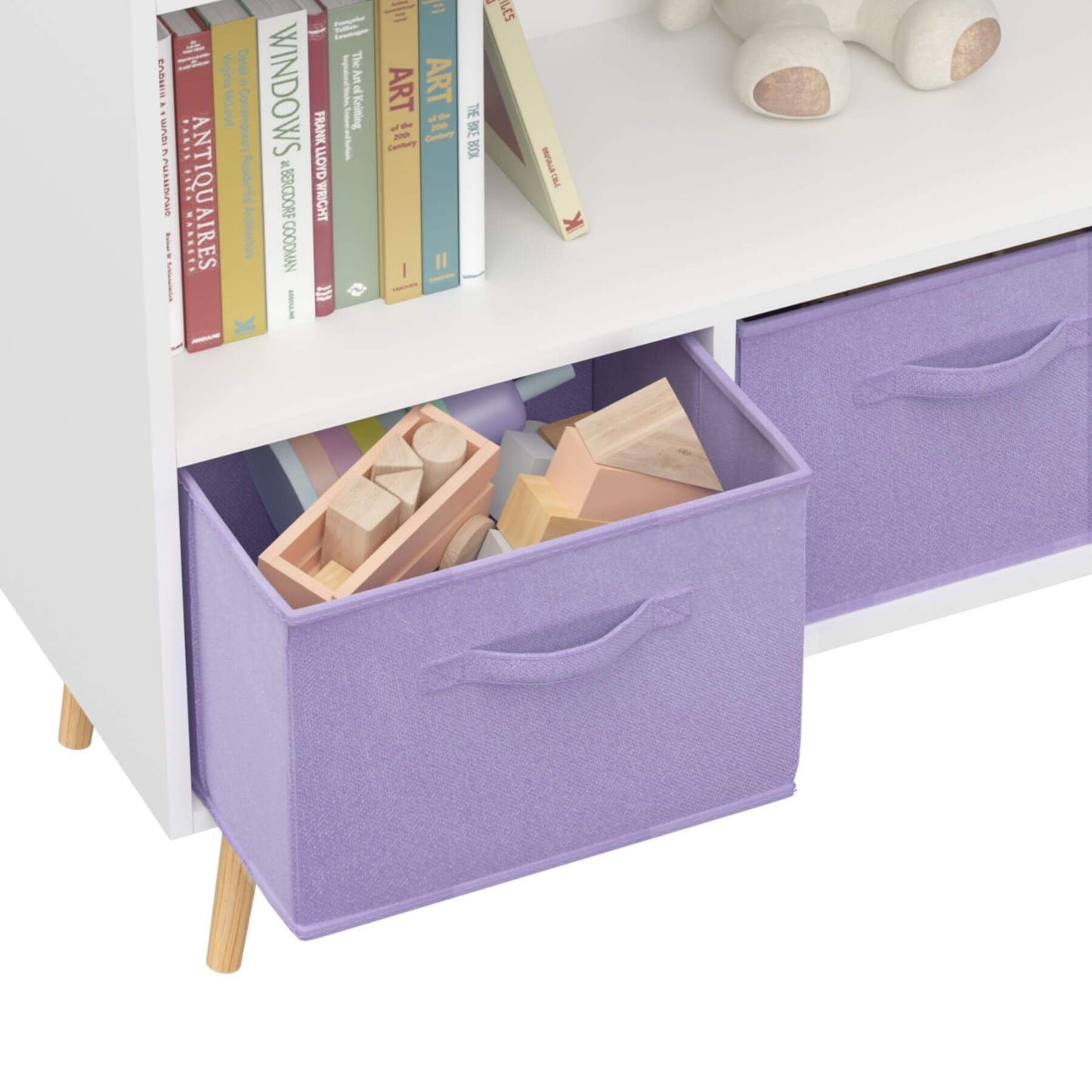 White dresser with purple storage bins containing toys and books on a white background