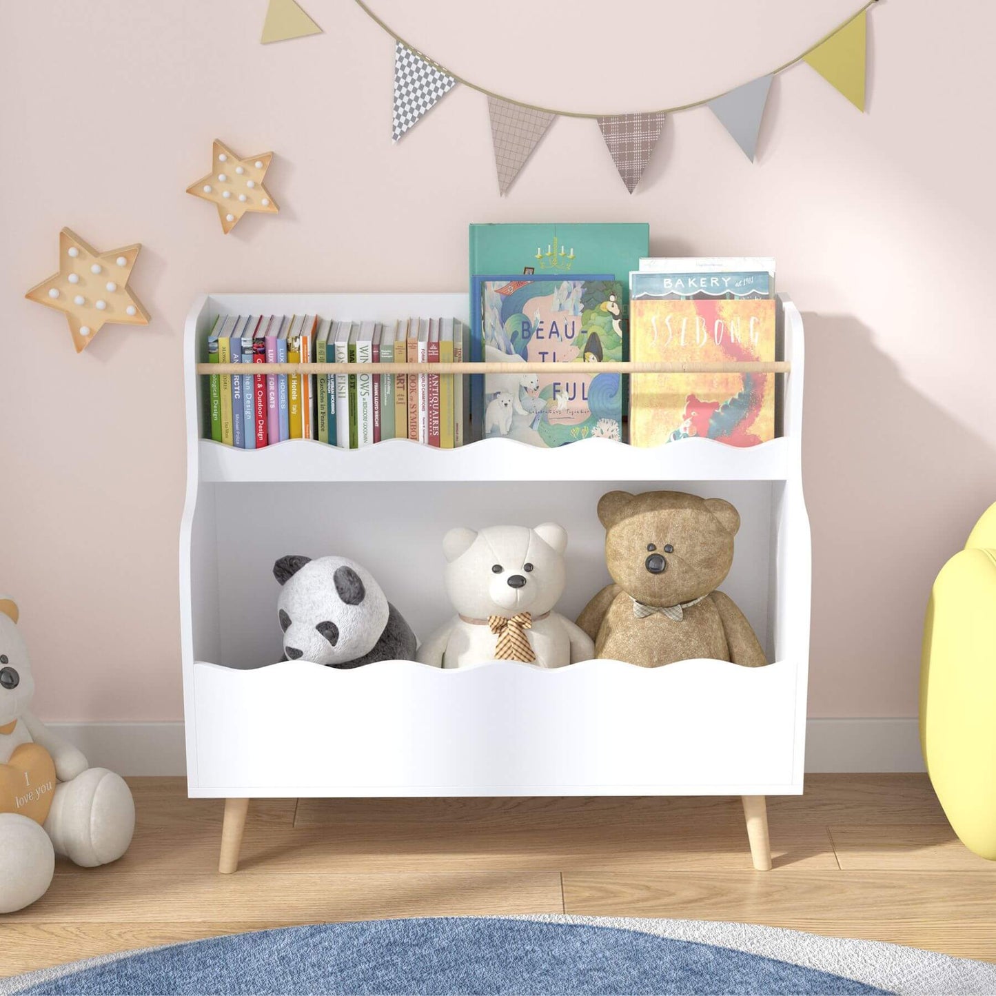 White children's bookshelf with books and stuffed animals against a light pink wall.