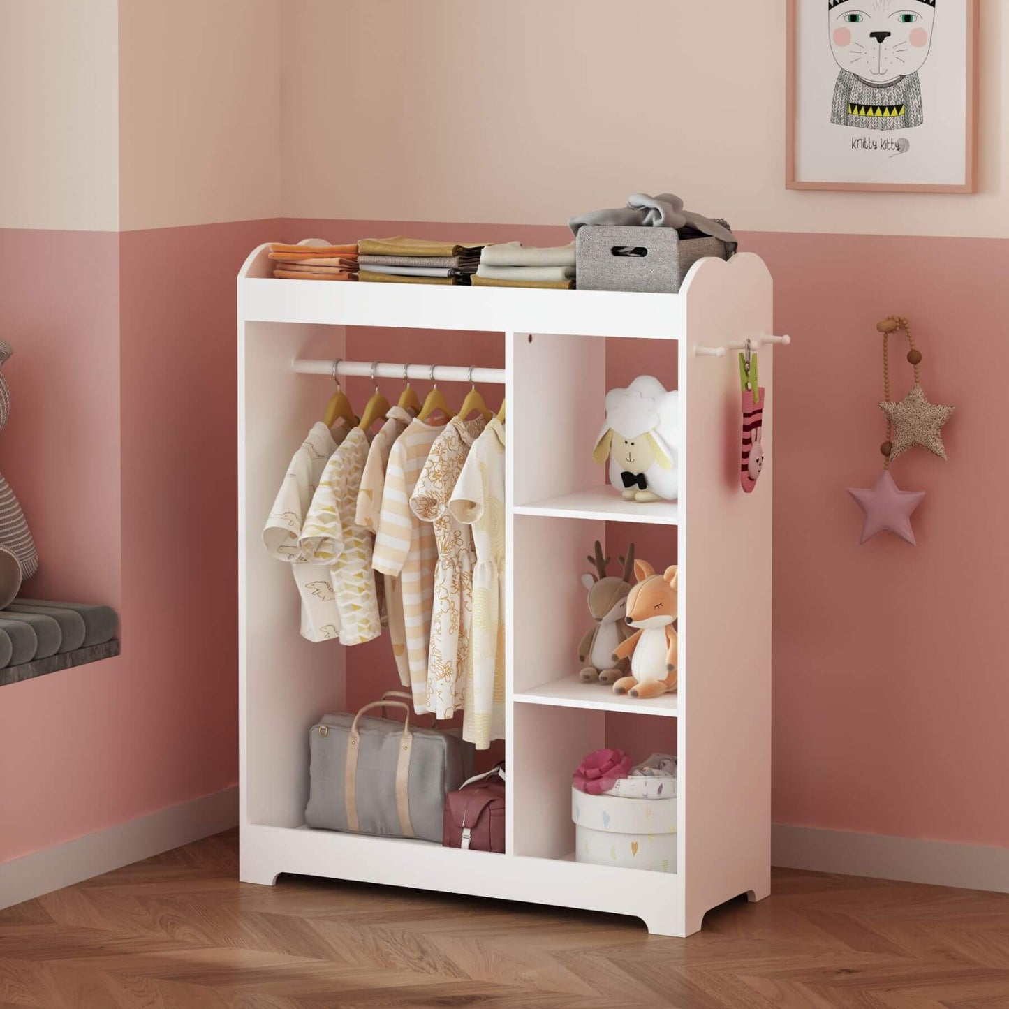 Children's wardrobe with clothes and toys in a room with pink walls.