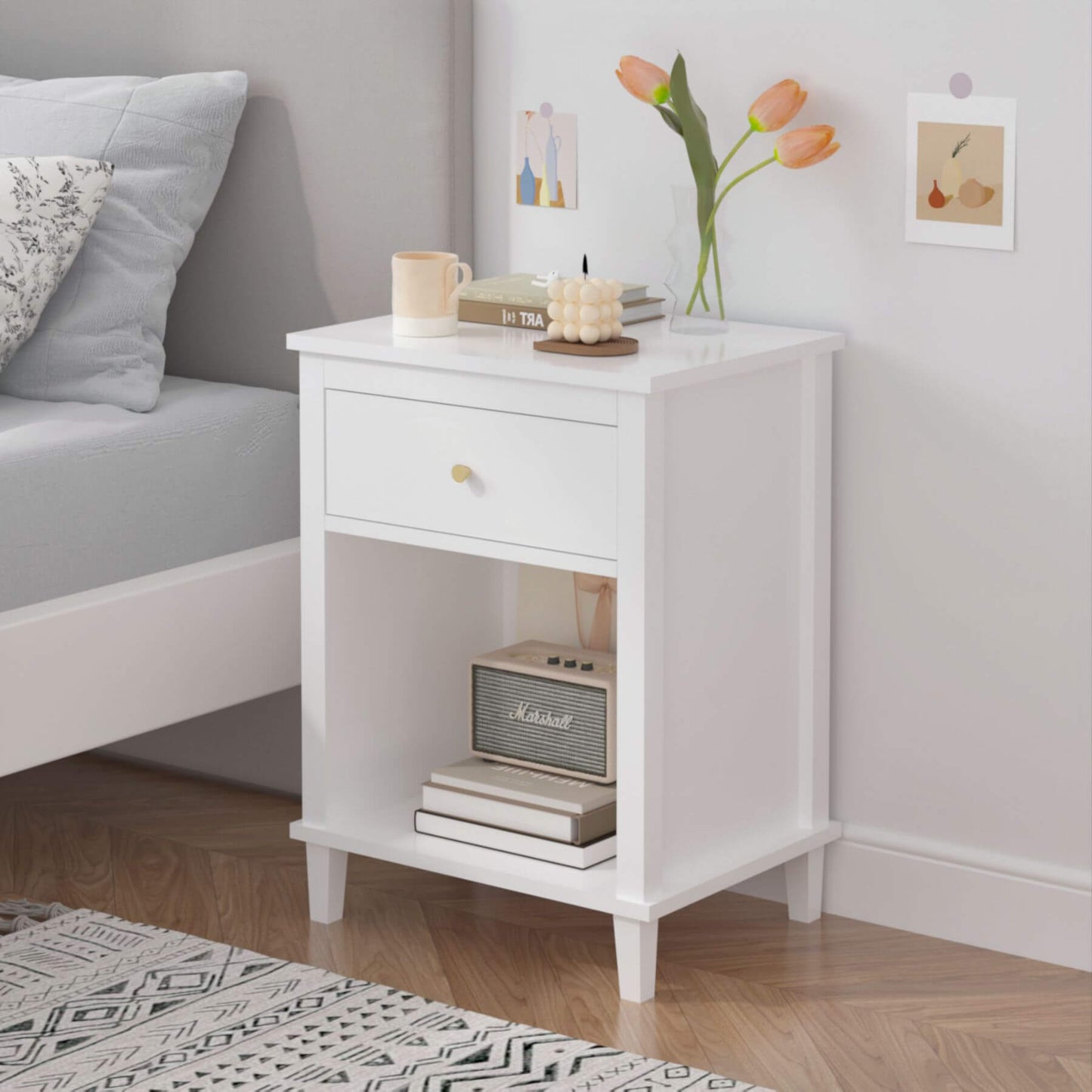 MOONRIVER Golden Handle Wooden Nightstand - White with books, a radio, and a vase of flowers next to a bed.