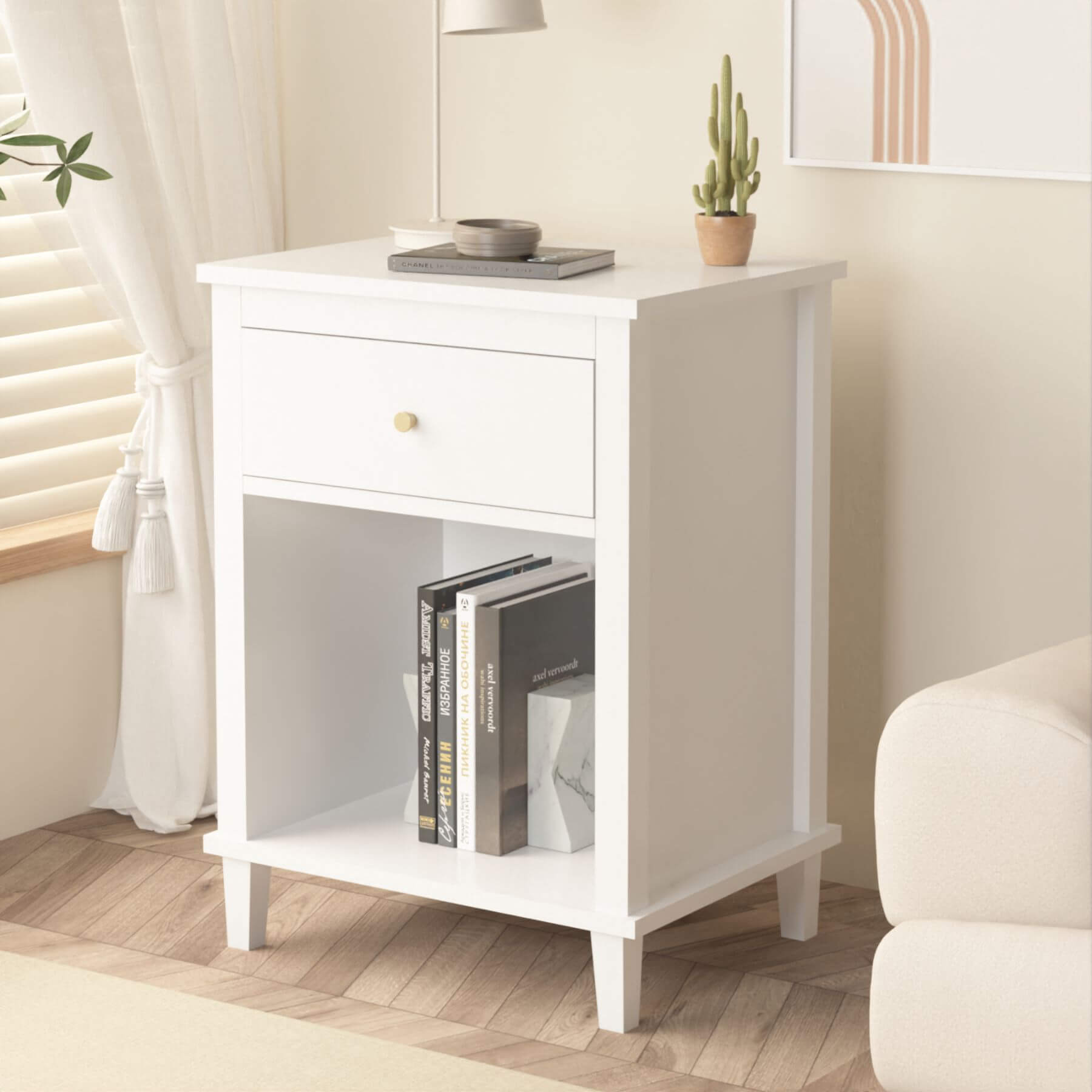MOONRIVER Golden Handle Wooden Nightstand - White with books and a plant in a room with a couch and curtains.