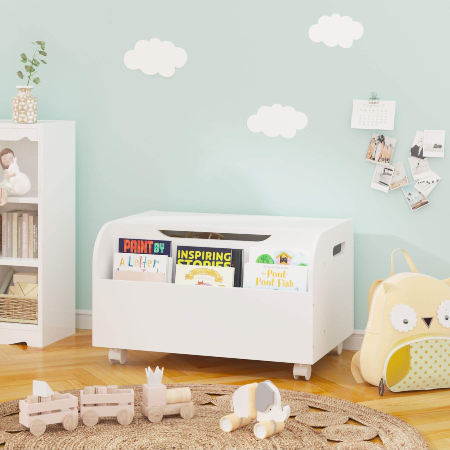 White toy storage box with books in a child's room with a light blue wall and wooden floor.