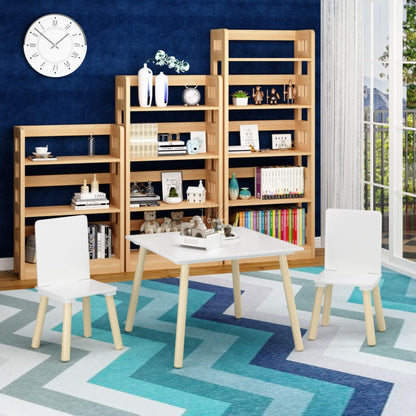 Dining area with wooden bookshelves, MOONRIVER Wooden Kids Table and 2 Chairs Set - White on a colorful rug.