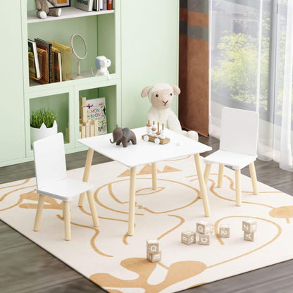 Children's play area with MOONRIVER Wooden Kids Table and 2 Chairs Set - White on a patterned rug, books, and toys in the background.