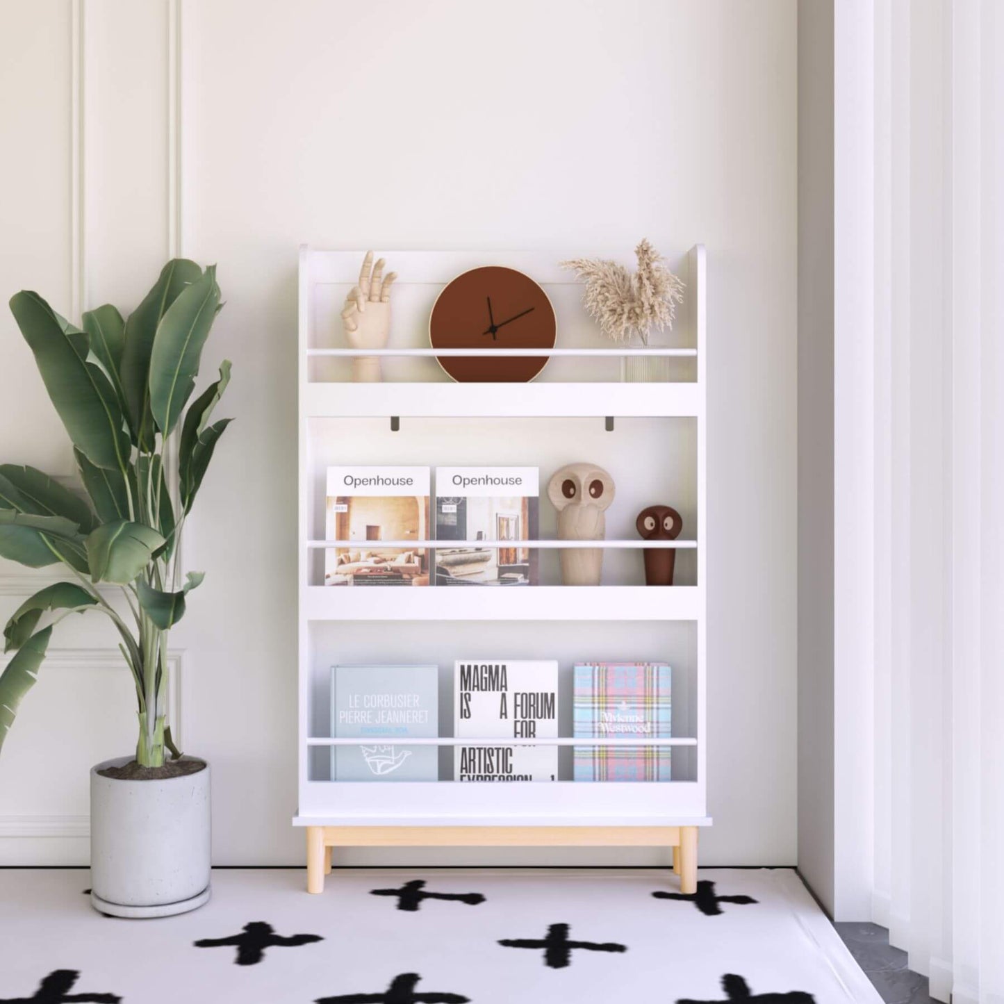 White bookshelf with decorative items against a white wall, next to a potted plant.